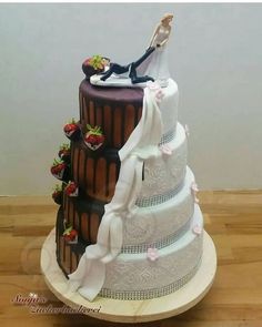 a three tiered wedding cake is decorated with strawberries and chocolate frosting on top