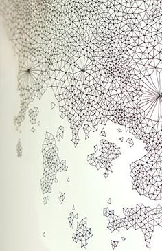 an artistic drawing on the wall in a room with white walls and black dots all over it