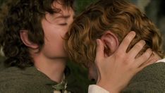 two young men are kissing each other in front of an image of the same person