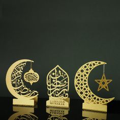 three wooden ornaments with arabic writing and a star in the middle on a black surface