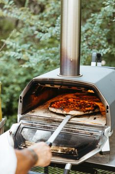 a pizza is being cooked in an outdoor oven