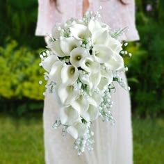 a woman holding a bouquet of white flowers