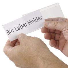 two hands holding a label that says bin label holder