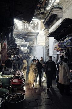 people are walking through an open market area