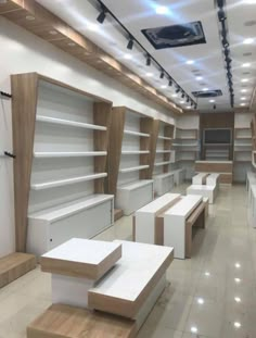 an empty store filled with lots of white shelves and wooden shelves on each side of the wall