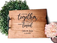 a wooden sign that says and so together they built the love with flowers next to it