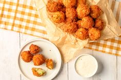 some fried food on a white plate next to a cup of milk and a napkin