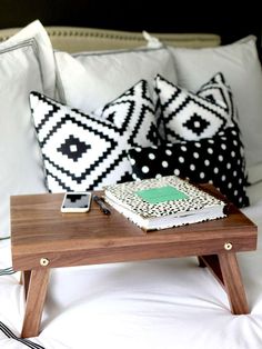 a cake sitting on top of a wooden table in front of two black and white pillows