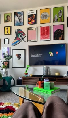 a living room with pictures on the wall and a glass table in front of it