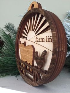 a wooden ornament with the words farm life and two camels on it