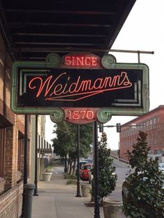 a neon sign on the side of a building that reads since wedmmans 1970