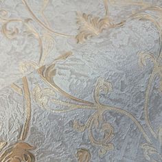 a close up view of a wallpaper with gold and silver designs on the fabric