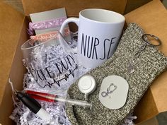 an open box containing personal items such as a mug, scissors, and other things