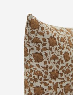 a brown and white pillow with flowers on it