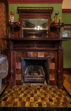 a fireplace in a room with green walls and wood trimmings on the mantle