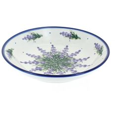 a blue and white bowl with purple flowers on it