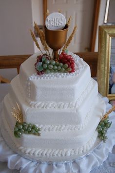 a three tiered wedding cake with white frosting and berries on the top layer