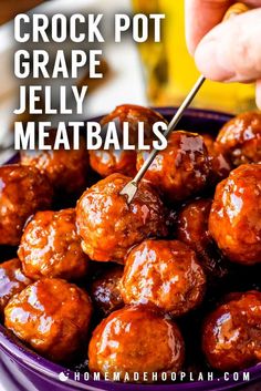 someone holding a skewer of crock pot grape jelly meatballs in a purple bowl