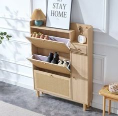 a wooden shelf with baskets and shoes on it next to a wall mounted sign that says stay home