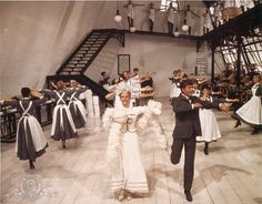 a man and woman dancing on the dance floor with other people in costume behind them