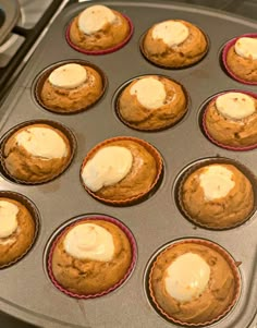 muffins with white frosting sitting in a pan on the stove ready to be baked