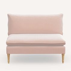 a pink couch sitting on top of a white floor