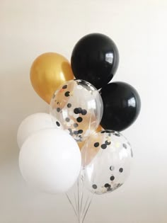 a bunch of balloons that are in the air with some black and white dots on them