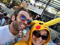 a man and woman wearing pokemon costumes pose for a photo