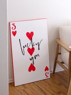 a card with hearts and the words lucky you written on it next to a chair