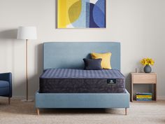 a blue bed sitting in a bedroom next to a chair