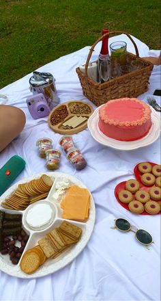 a table topped with lots of food on top of a white tablecloth covered field