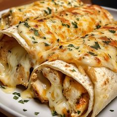 a white plate topped with two quesadillas covered in cheese and garnished with parsley