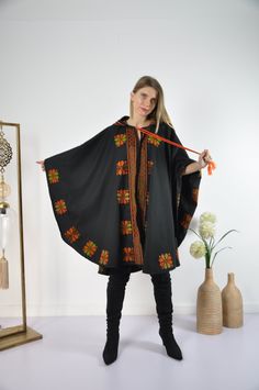 This vintage cape jacket is definitely a vintage fashion statement. It is 100% hand embroidered with geometrical patterns. It can be used over a jeans and shirt or sweater. Great to keep you warm. Please note that the capes we have at the moment (Option #1 and Option #2) are without a hoodie but they are just as beautiful and practical. Material : Wool Length : 49 inches Size : One size fits all. We ship your order with DHL express within one to two business days. Orders to Europe will typically Traditional One-size Outerwear For Fall, Wool Cape Shawl For Winter, Winter Costume Cape Outerwear, Traditional Black Cape For Fall, Embroidered Costume Outerwear For Fall, Traditional One-size Cape For Fall, Bohemian Wool Cape For Fall, Traditional One Size Cape For Fall, One Size Hooded Cape For Fall