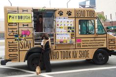 a woman walking her dog in front of a food truck