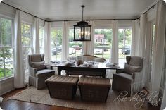 a dining room table with four chairs and a bench in front of large windows that look out onto the street