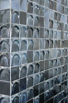 a wall made up of metal tiles with circles on it's sides and one in the middle