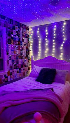 a bedroom with purple lighting and pictures on the wall above the bed, along with a star ceiling