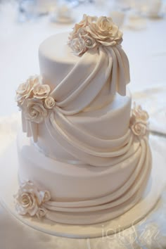 a three tiered white wedding cake with flowers on it