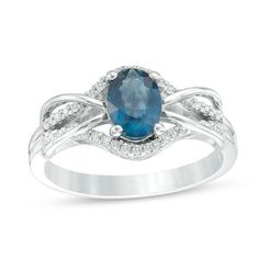 an oval blue sapphire and diamond ring with white diamonds on the shoulders, set in 18k white gold