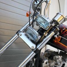 a close up view of the handlebars on a motorbike that is parked in front of a garage