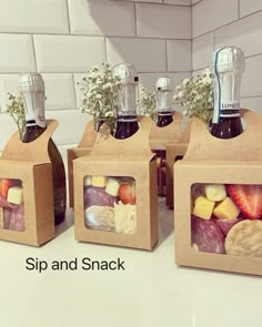 three boxes filled with different types of food and drinks sitting on top of a counter