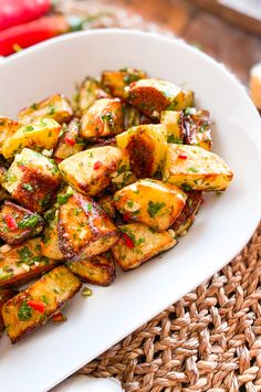 a white plate topped with fried potatoes on top of a table