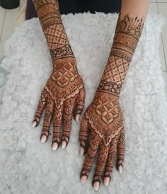 two hands with henna tattoos on them