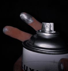 a can with two fingers sticking out of it's top and the other end