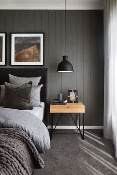 a bed room with a neatly made bed and a night stand next to the window