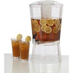 two glasses filled with iced tea and lemon slices next to a pitcher of iced tea