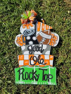 an orange and black sign that says rock'n'roll on it in the grass