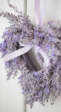 a lavender wreath hanging on the side of a door