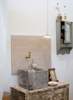 a bathroom sink sitting on top of a wooden cabinet next to a wall mounted clock