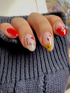 a woman's hand with red and white nail polish on her nails, holding onto a gray sweater